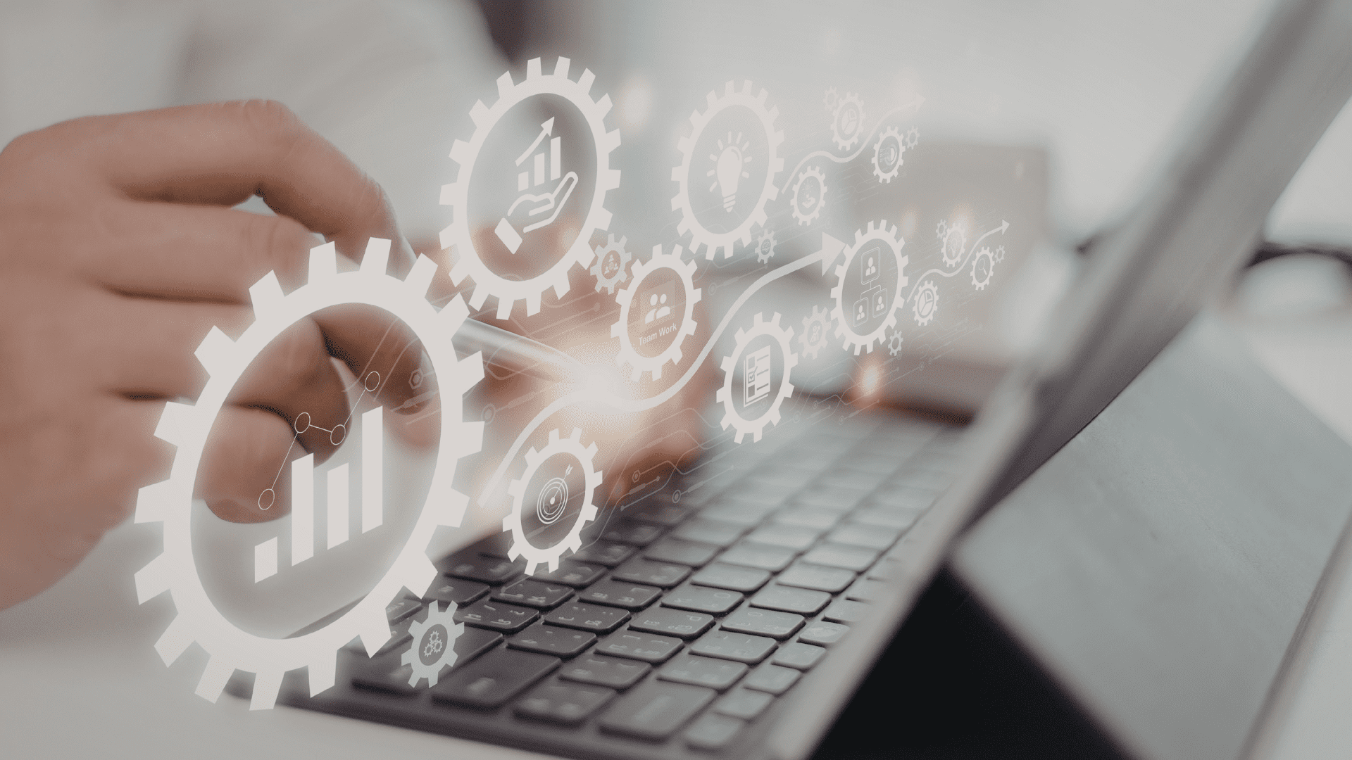 Close-up of a laptop with digital automation gears and workflow icons representing marketing automation systems used by small businesses and implemented by Deacon Solutions.